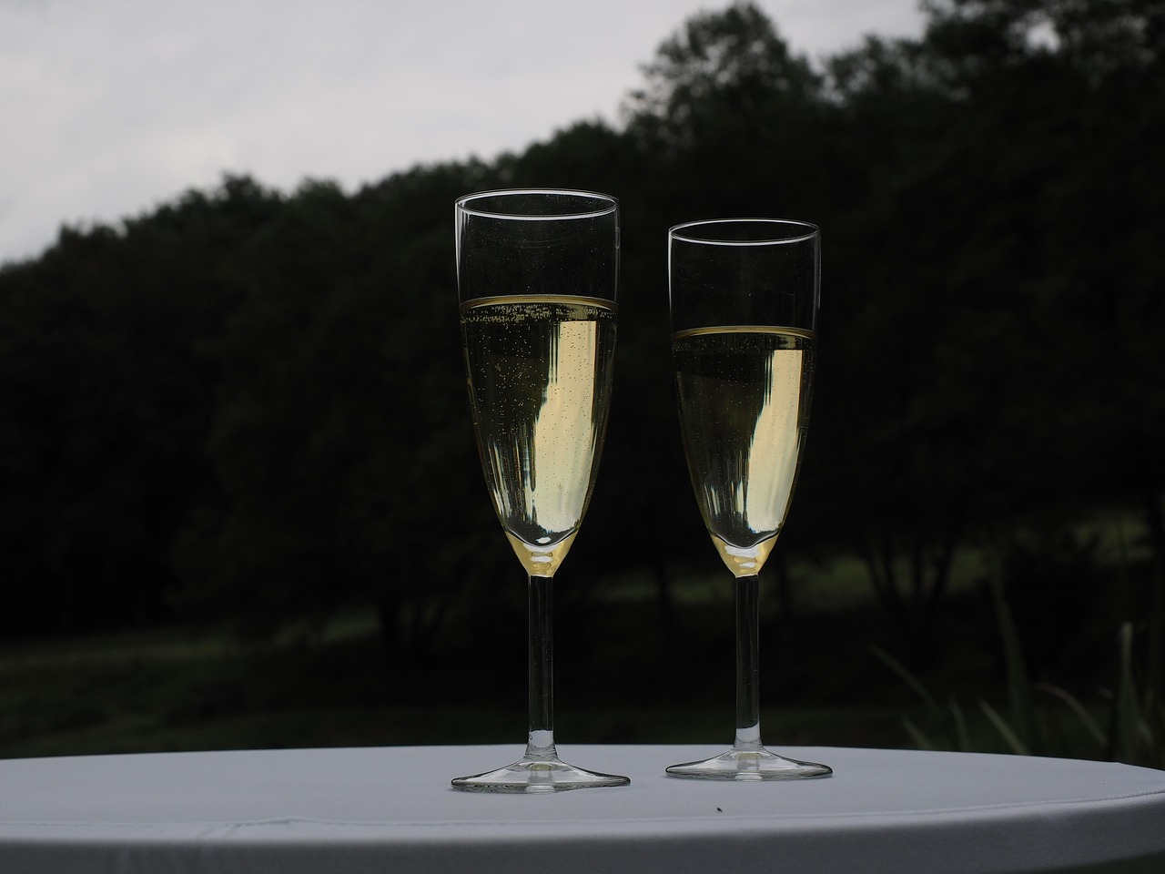 To glas med mousserende vin på et hvidt bord.