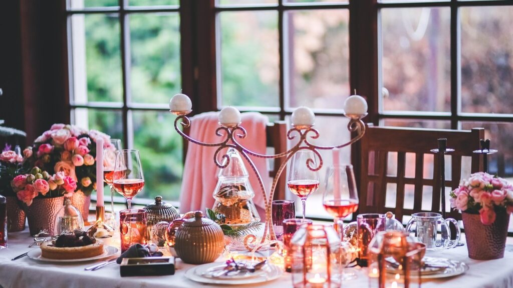 Juledækket bord med glas rosé, lys og blomster